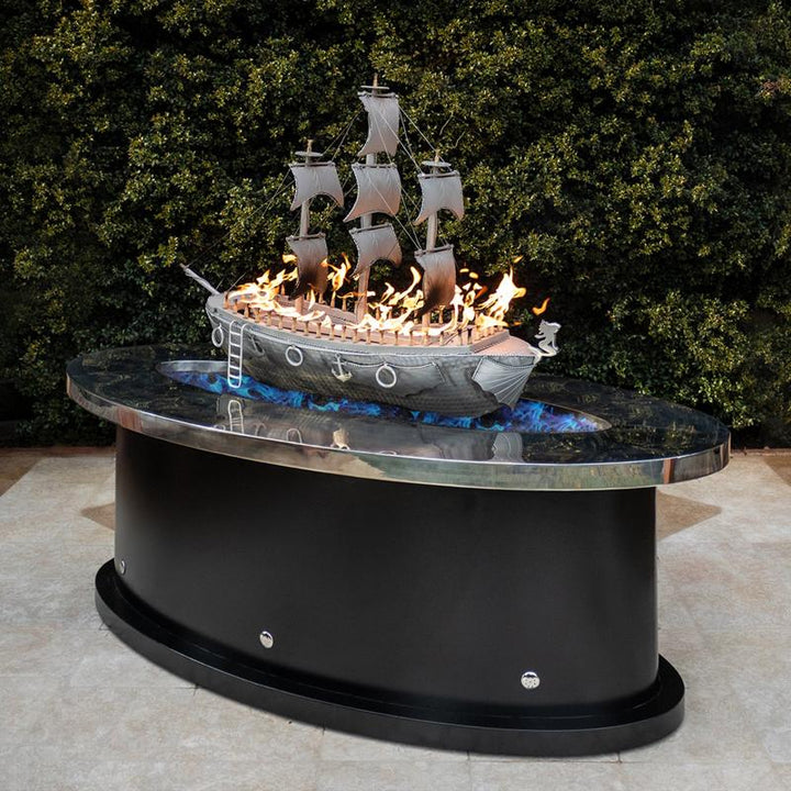 La Pinta fire pit statue a metal flaming boat floating on a sea of flames.
