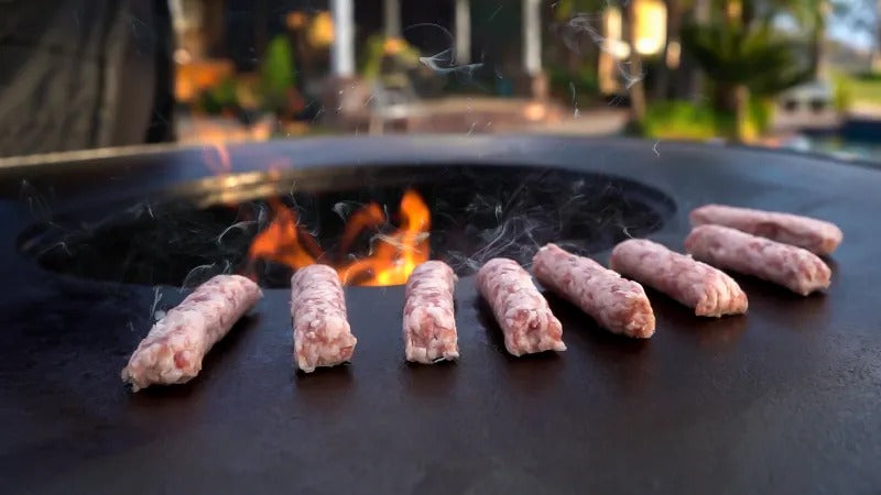 A close up of cooking sausages on a Mojave grill.