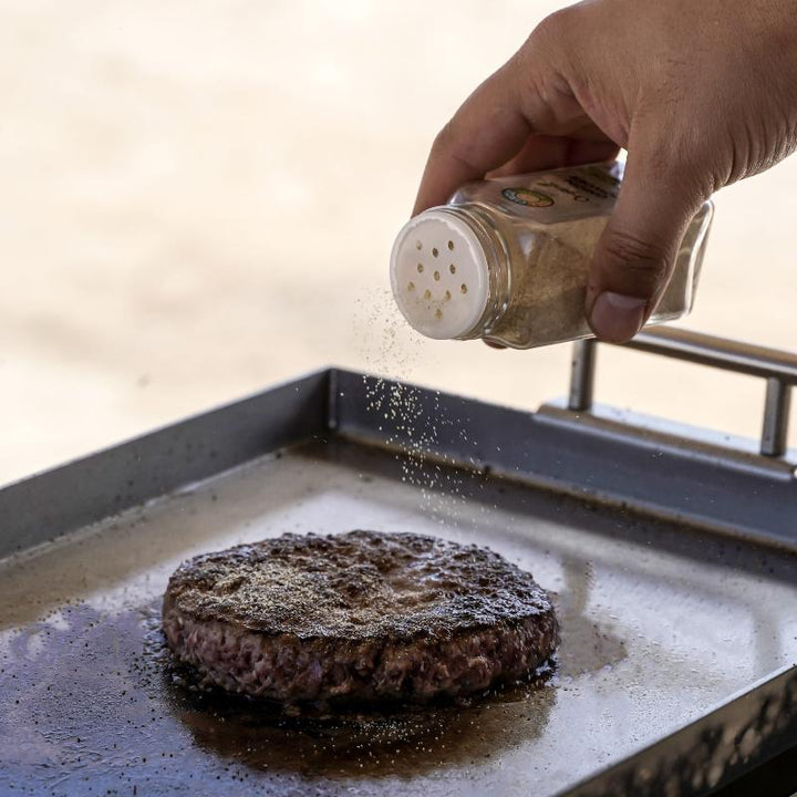 Spicing up a hamburger on the Overlander grill.