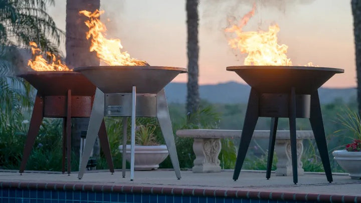 A low view of 3 Mojave Grills at sunset - powder coated black, stainless steel and corten steel.