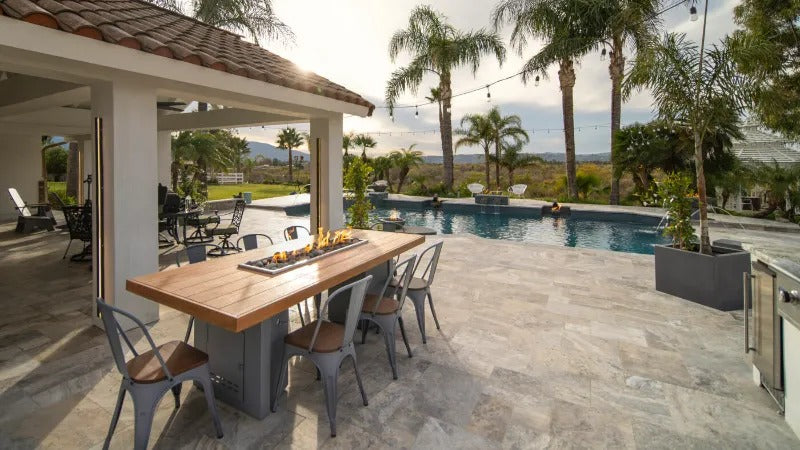 Patio view of an Alameda Wood Top Fire Table as part of an outdoor kitchen.