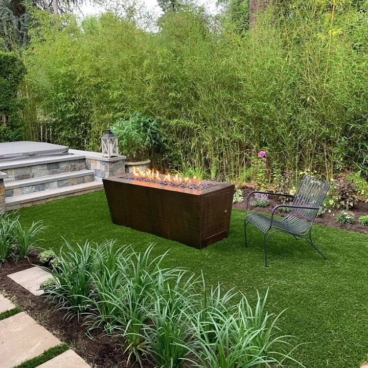 The Outdoor Plus Mesa fire pit hammered copper 60 inch lit in backyard