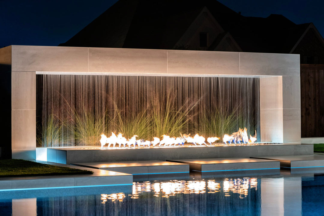 The Outdoor Plus Williams Fireplace with scupper at night poolside