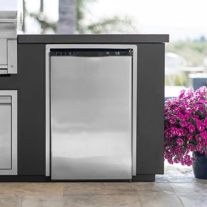 Stainless steel Videl outdoor refrigerator on a patio with flowers in the background